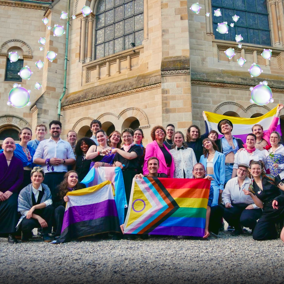 Das queerchor vor der Pauluskirche Basel im Gruppenfoto mit Pride-Flaggen